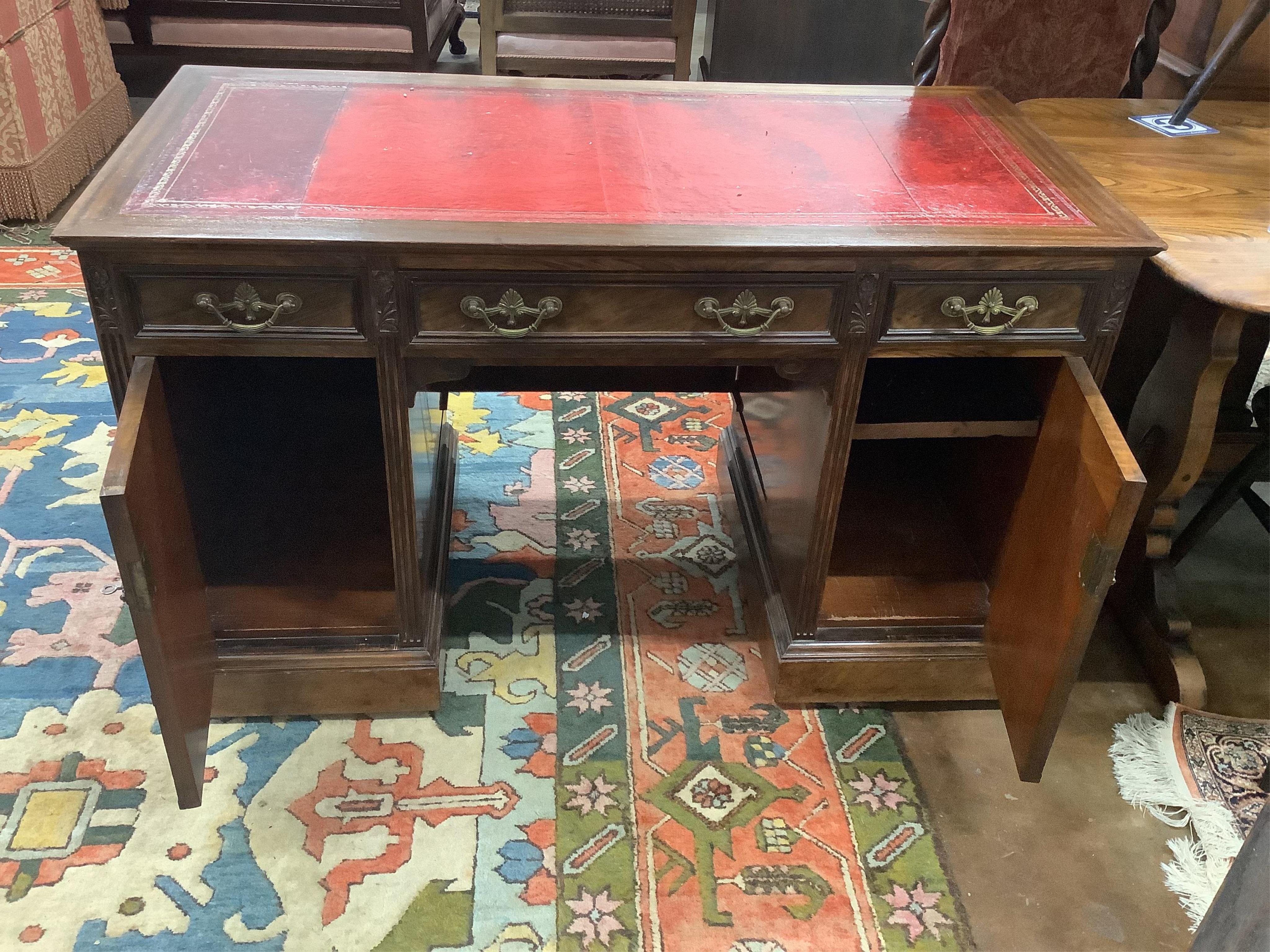 An Edwardian mahogany pedestal desk, pedestals with dummy front drawers, width 121cm, depth 59cm, height 73cm. Condition - fair to good